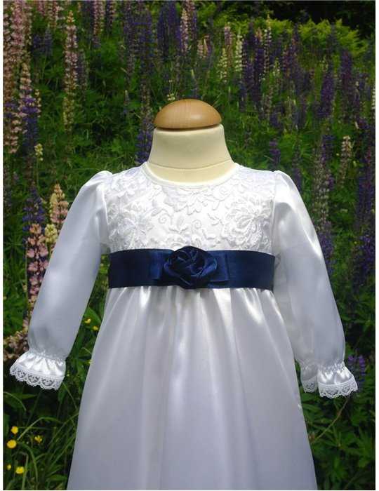 Dopklänning i vitt tyg med marinblå rosett