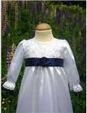 Dopklänning i vitt tyg med marinblå rosett
