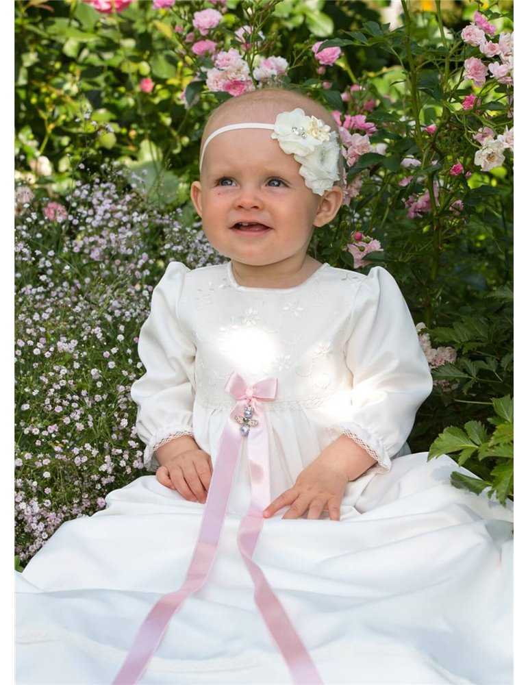 Dopklänning på gullig flicka bland blommor
